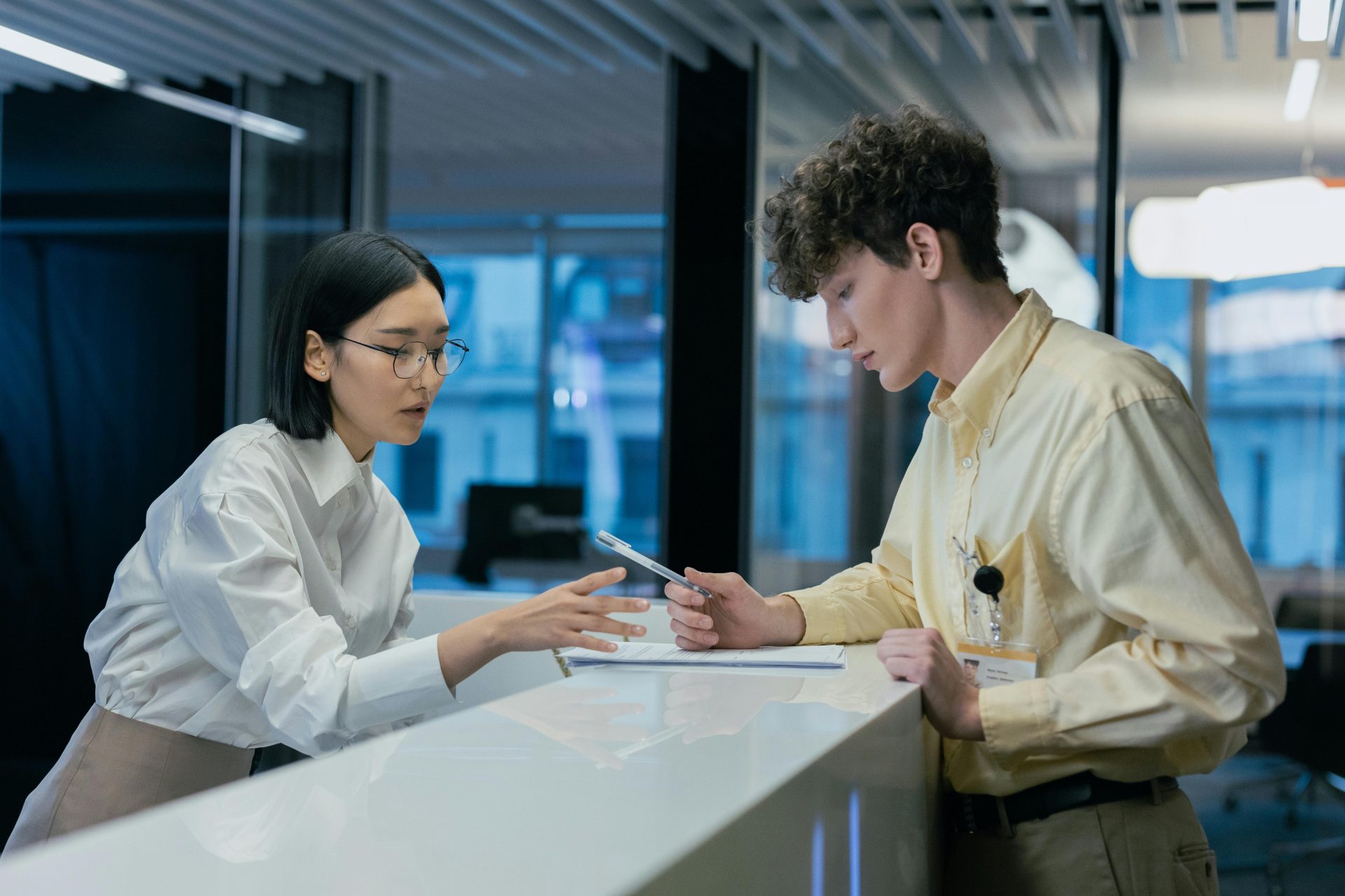 Zwei Fachkräfte im Gespräch an einem modernen Empfang – Teamwork und Kundenservice im Fokus.